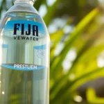 Prominently display FDA recalls Fiji water with a close-up shot of a bottle against lush greenery.